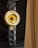 A tall, rectangular speaker tower with multiple circular speaker units. Two large, golden horn-like structures are mounted on the front, creating a striking visual contrast against the black speakers and drapery.