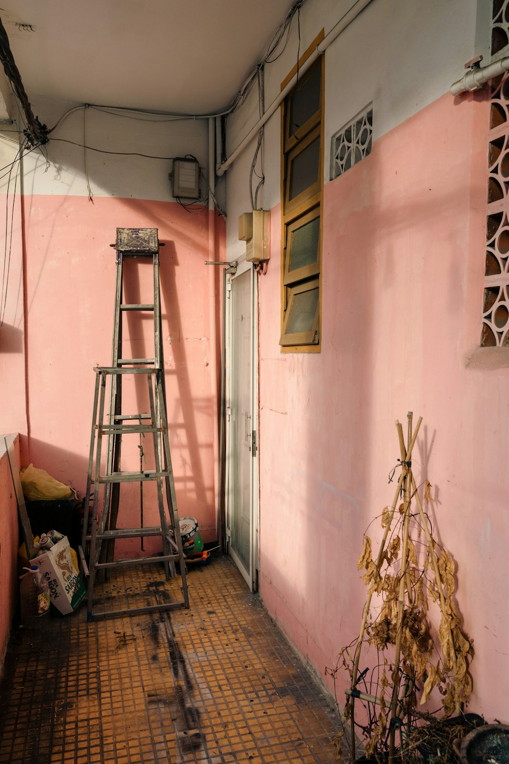 a ladder leaning up against a pink wall