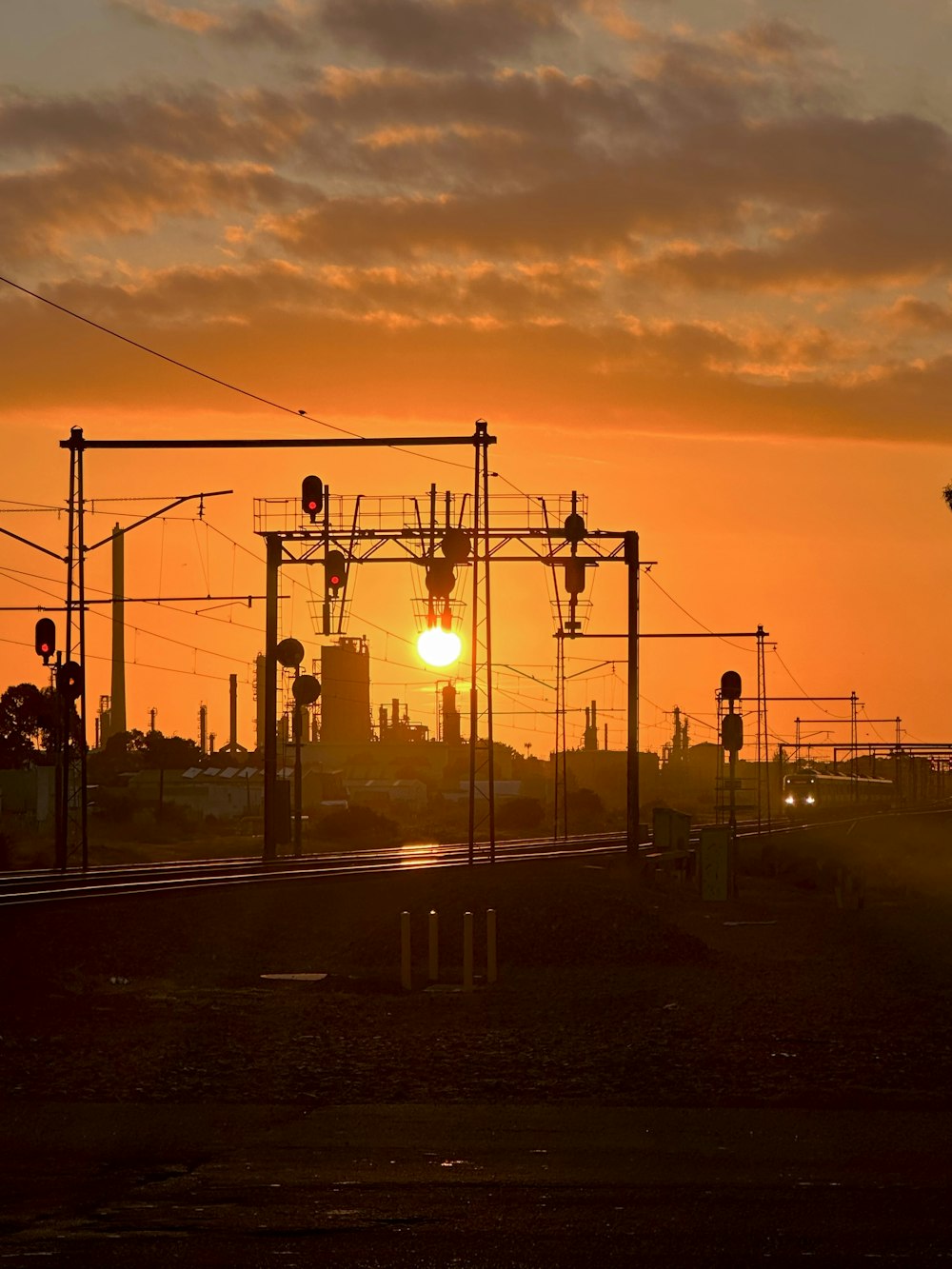 the sun is setting over a train track