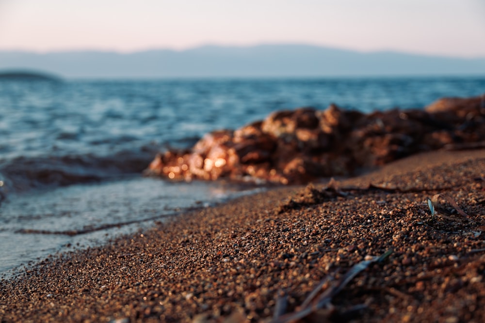 a close up of a beach with a wave coming in