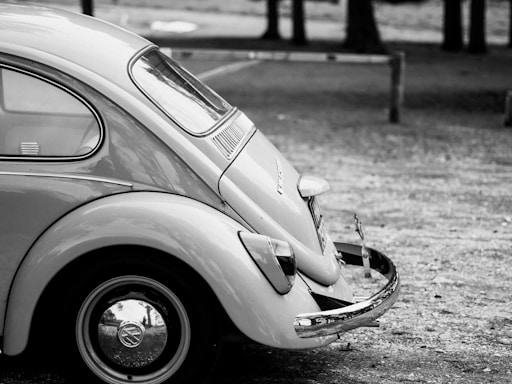 A sleek, minimalist photo of a classic Volkswagen Beetle parked against a clean white wall, capturing the essence of volks gallery.