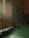 A dimly lit room with a pool table in partial focus. Sunlight streams through, creating a warm, inviting atmosphere. Some pool balls are positioned on the table. An old wooden cabinet and bar stools are faintly visible in the background.