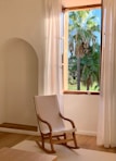 A comfy rocking chair in a bright sunroom, perfect for relaxing moments.