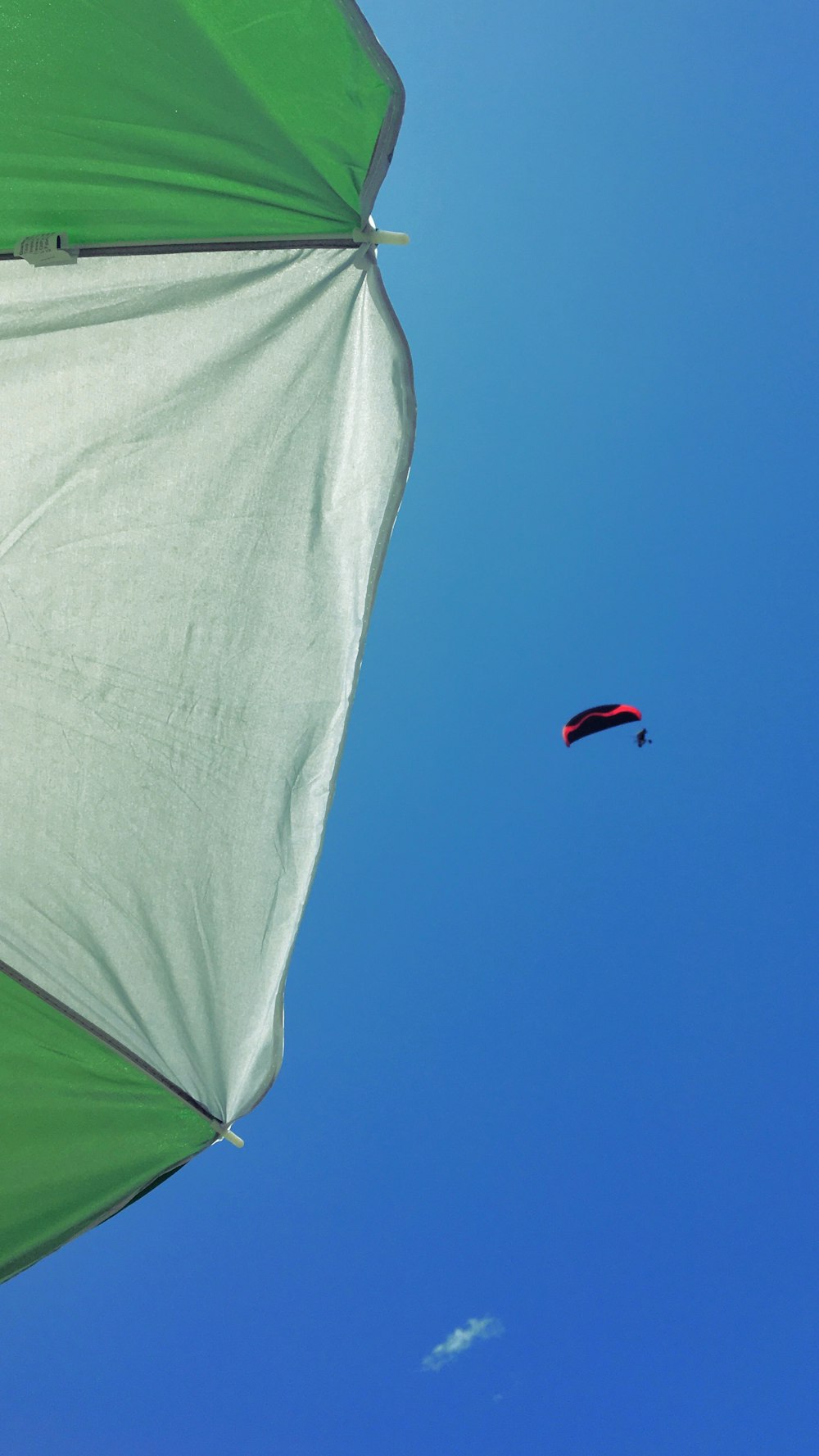 a parasail is flying high in the blue sky