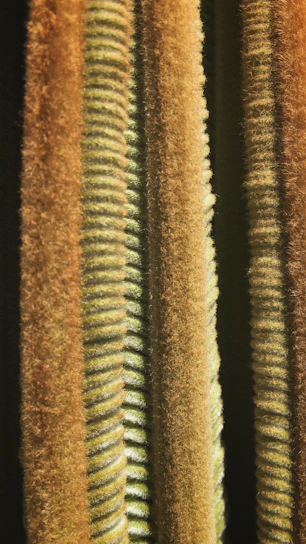 Close-up of rugged outdoor jacket fabric layered with industrial textures in deep iron gray and burnt rust tones.