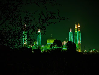 Evening shot of a mosque illuminated with soft green and white lights symbolizing hope