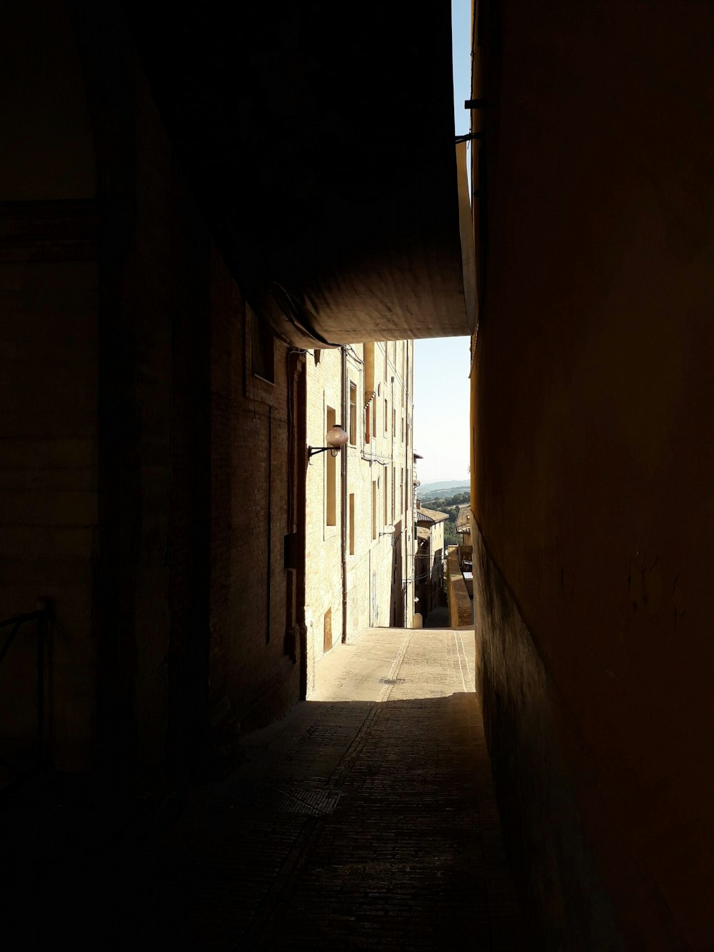 a narrow alley way with a person walking down it