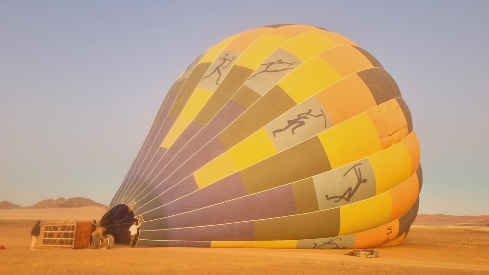 a large hot air balloon sitting in the middle of a desert