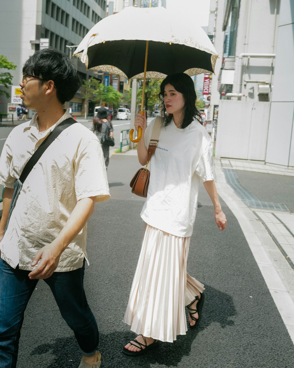a man and a woman walking down a street under an umbrella