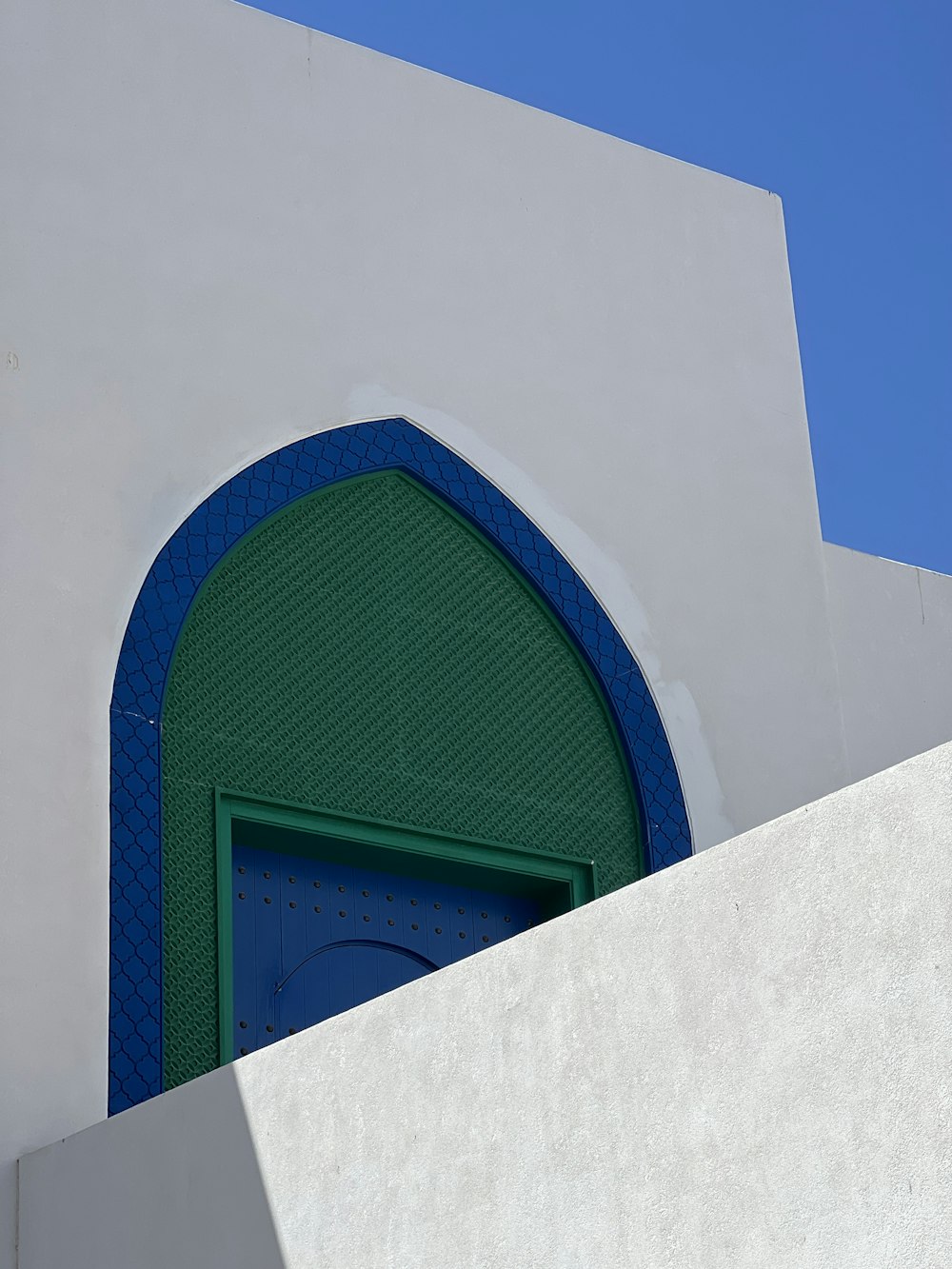 a white building with a blue and green door