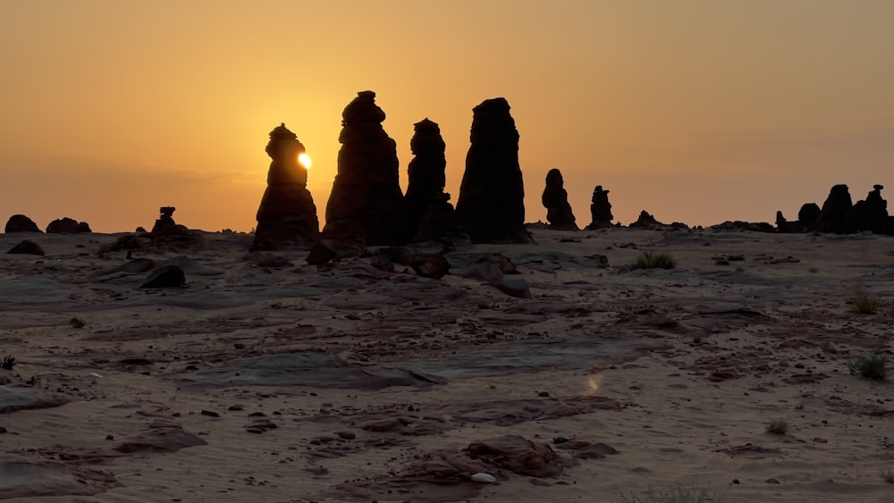 the sun is setting behind the rocks in the desert