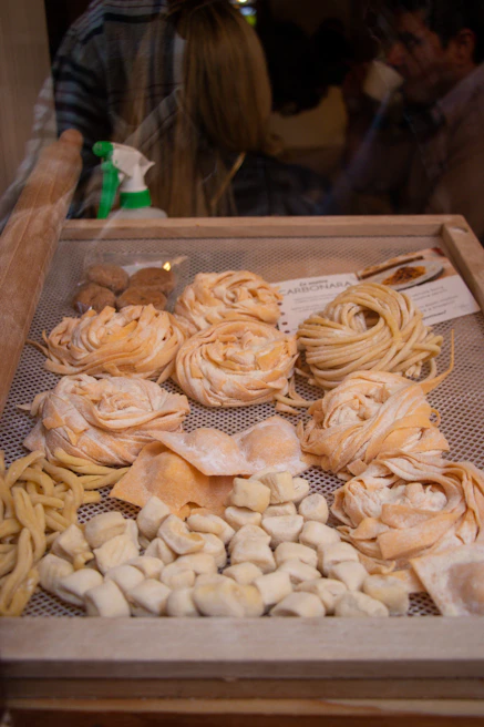 Colorful assortment of handmade pasta shapes displayed on a kitchen counter
