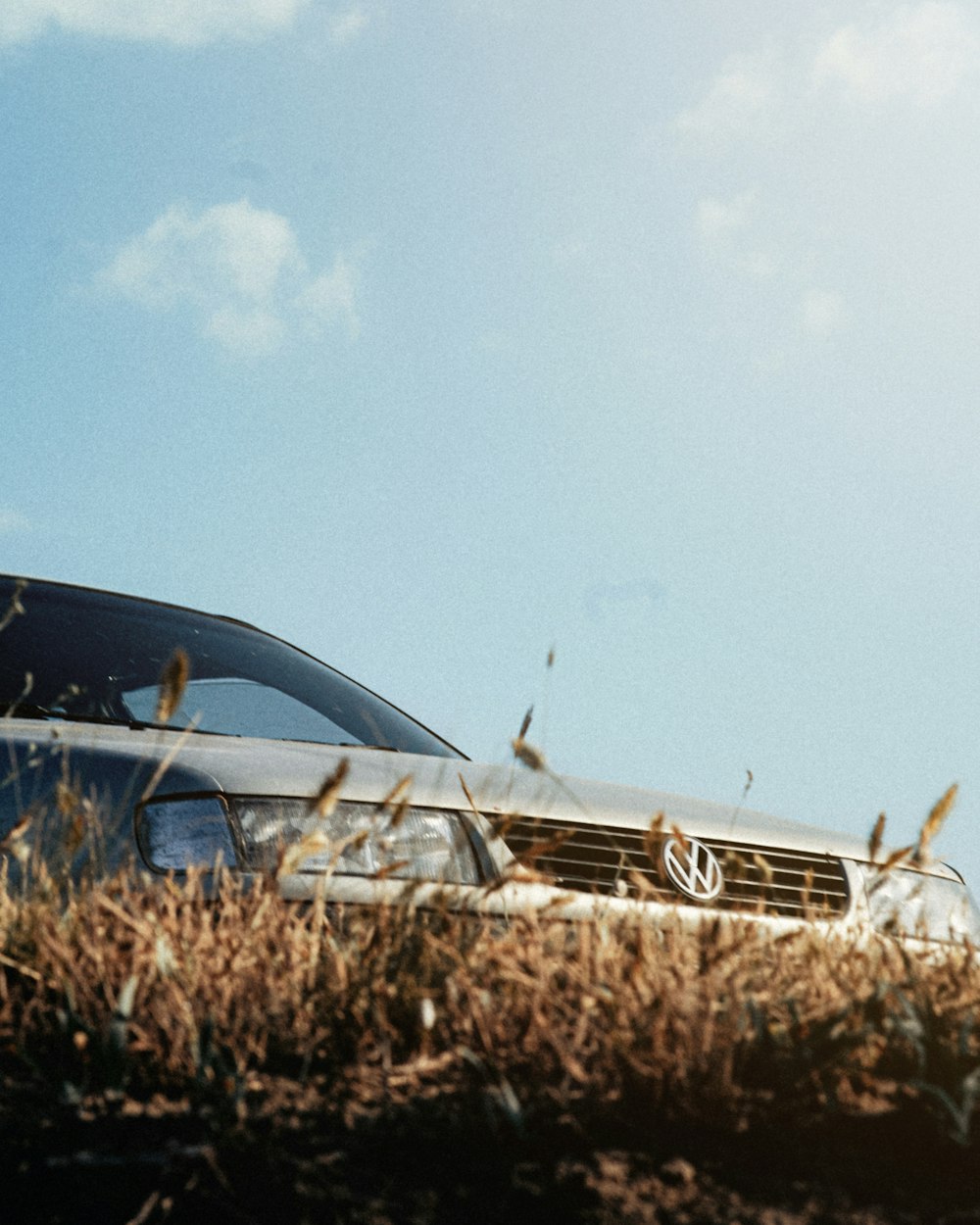 a car parked in a field of tall grass