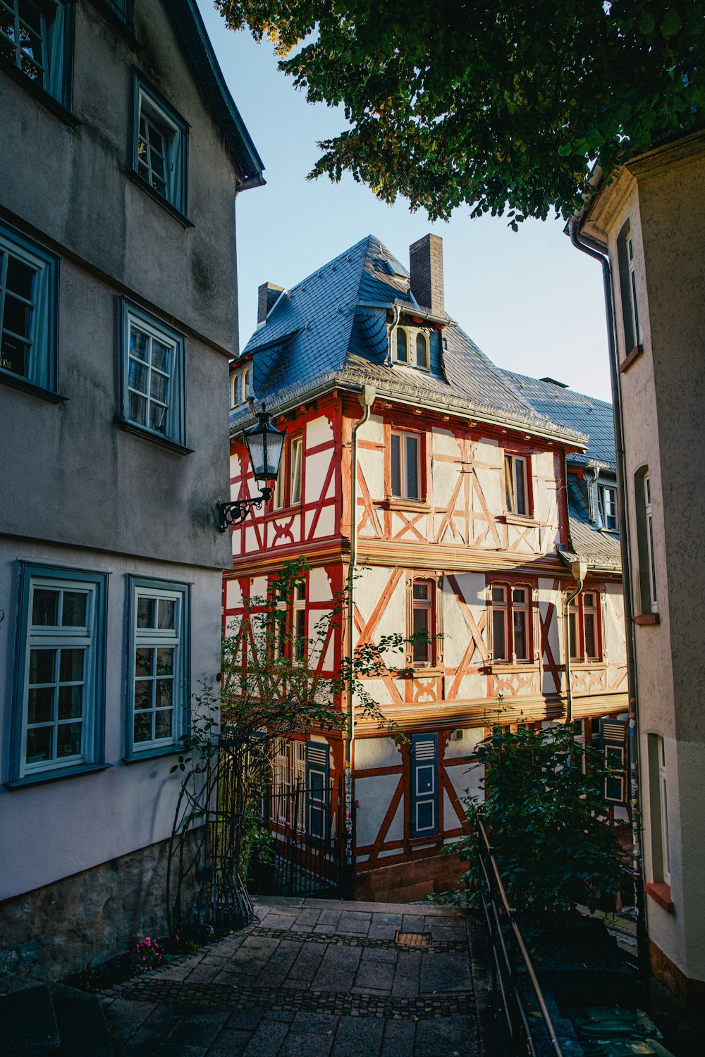 Ein hohes Gebäude mit blauem Dach neben einem Baum