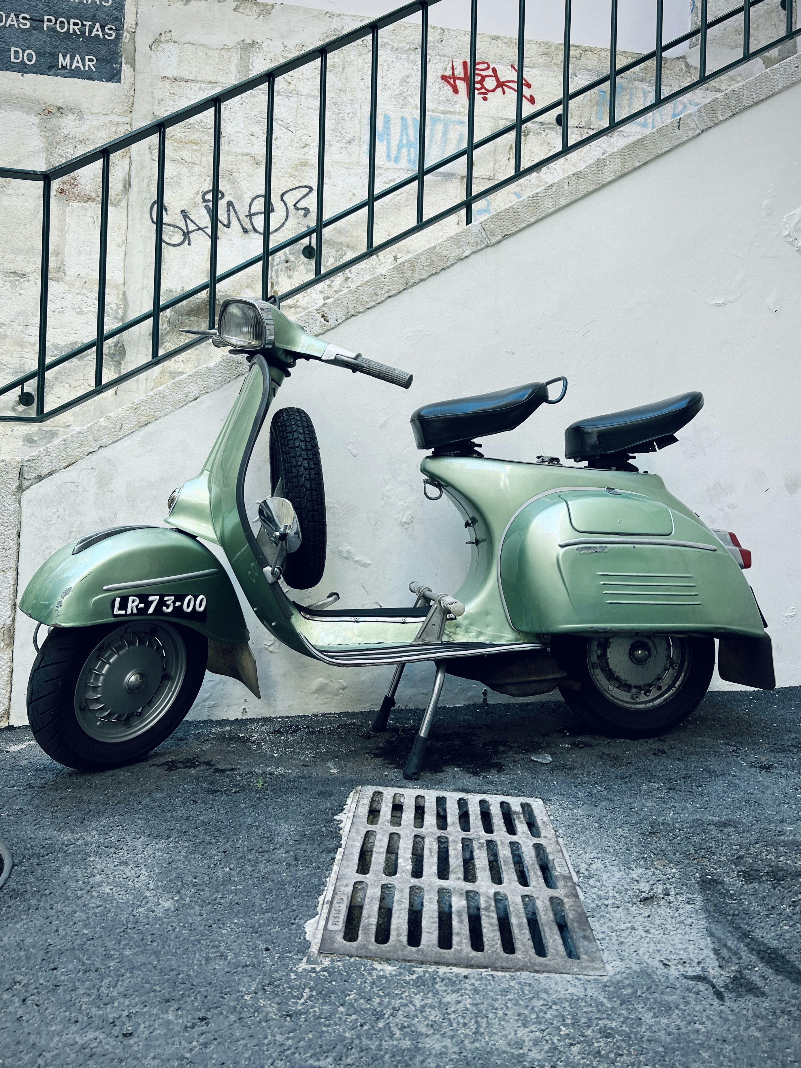 a green scooter parked next to a stair case