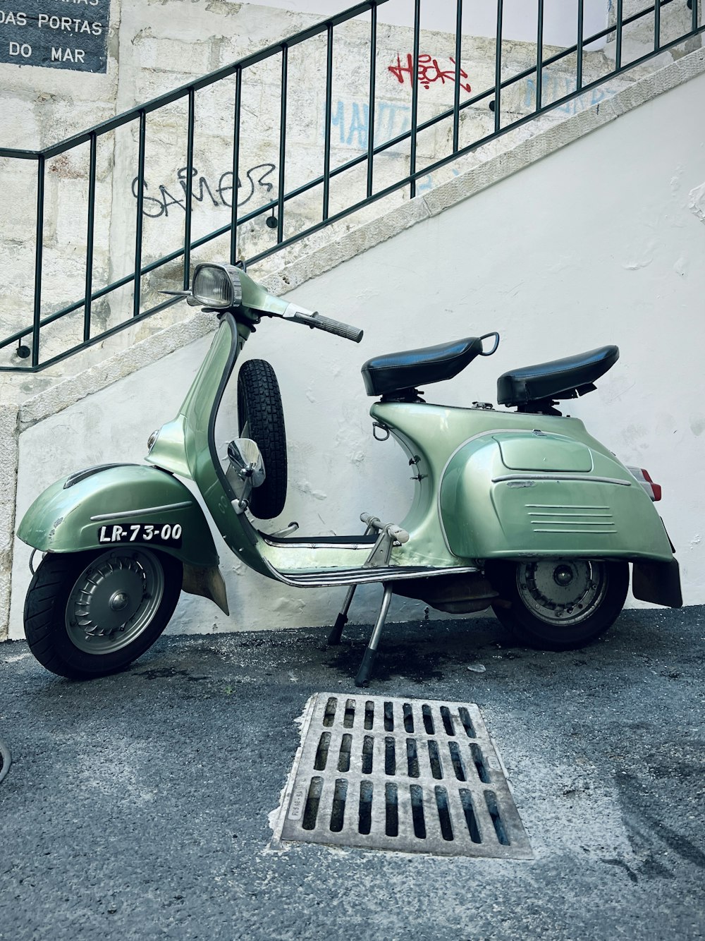 a green scooter parked next to a stair case