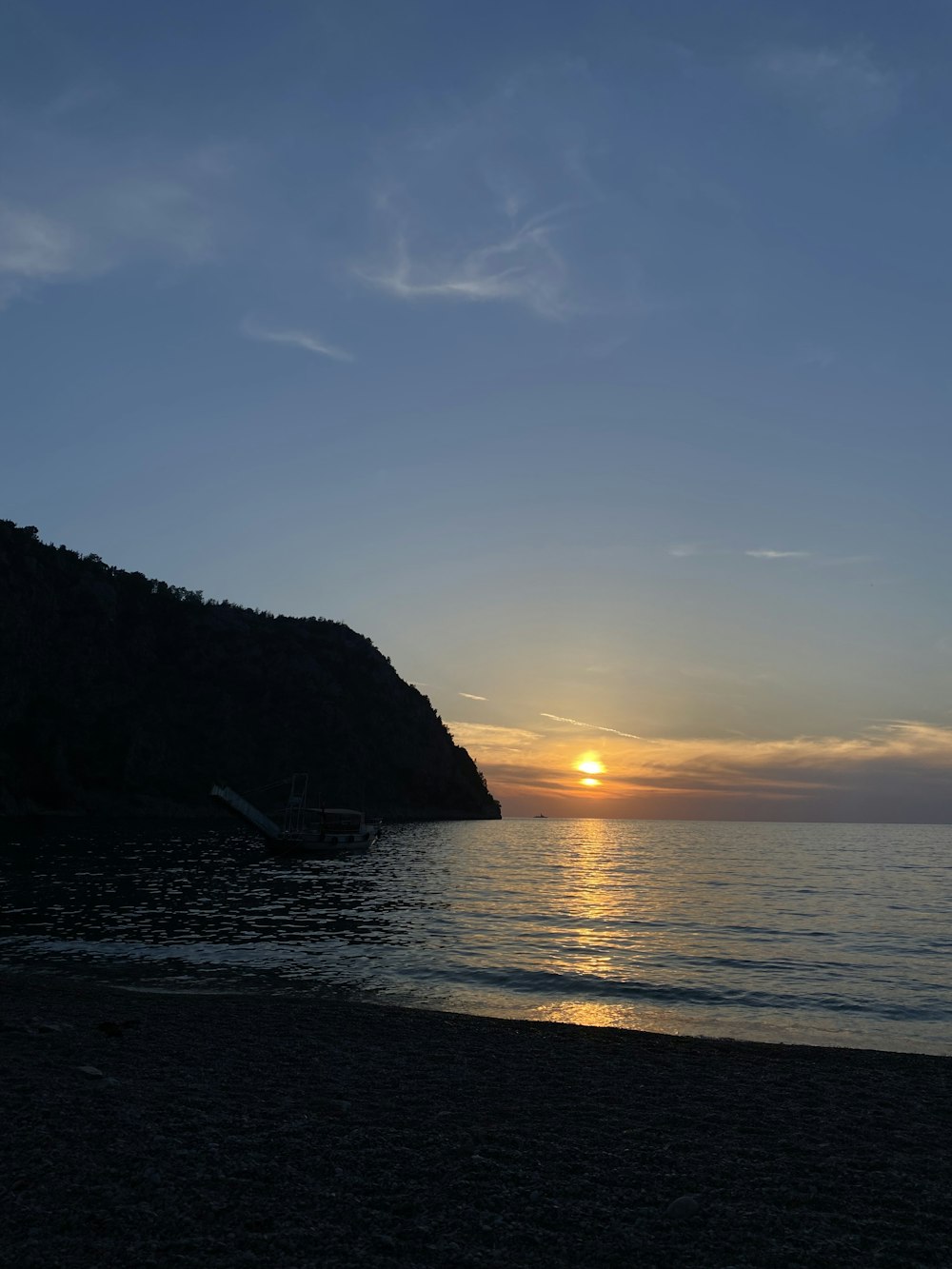 the sun is setting over the water at the beach