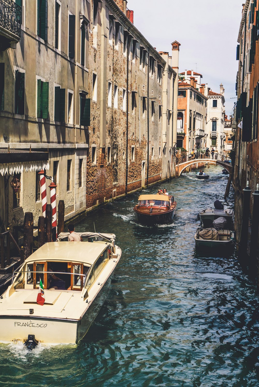 a boat traveling down a river next to tall buildings