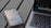 A smartphone with an app screen is placed next to a laptop with a visible keyboard and part of the screen. The phone displays various app icons and images, while the laptop shows a desktop with multiple application icons.