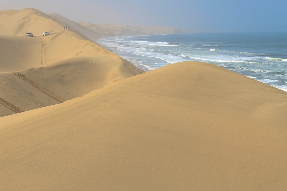 a sandy beach with a body of water in the distance