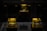 Three illuminated crystal cubes rest on wooden bases, each displaying intricate celestial designs that appear to be etched or embedded within the glass. The cubes are lit with a warm, yellow glow, emphasizing the details of the celestial objects, which resemble planets or moons. The background is dark, enhancing the visibility of the glowing cubes.