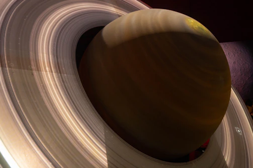 Close-up of a glowing planet with rings against a dark cosmic background