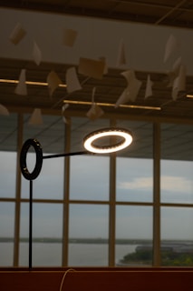 A giant lamp casting soft light over a stack of design sketches and fabric samples.