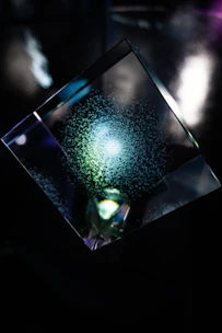 A prism embedded within a lens, glowing softly as it changes color with light.