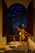 A cozy reading nook bathed in soft moonlight with a telescope by the window.