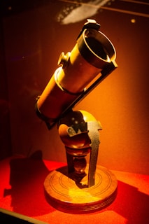 A vintage brass telescope resting on a polished wooden tripod, evoking maritime adventures.