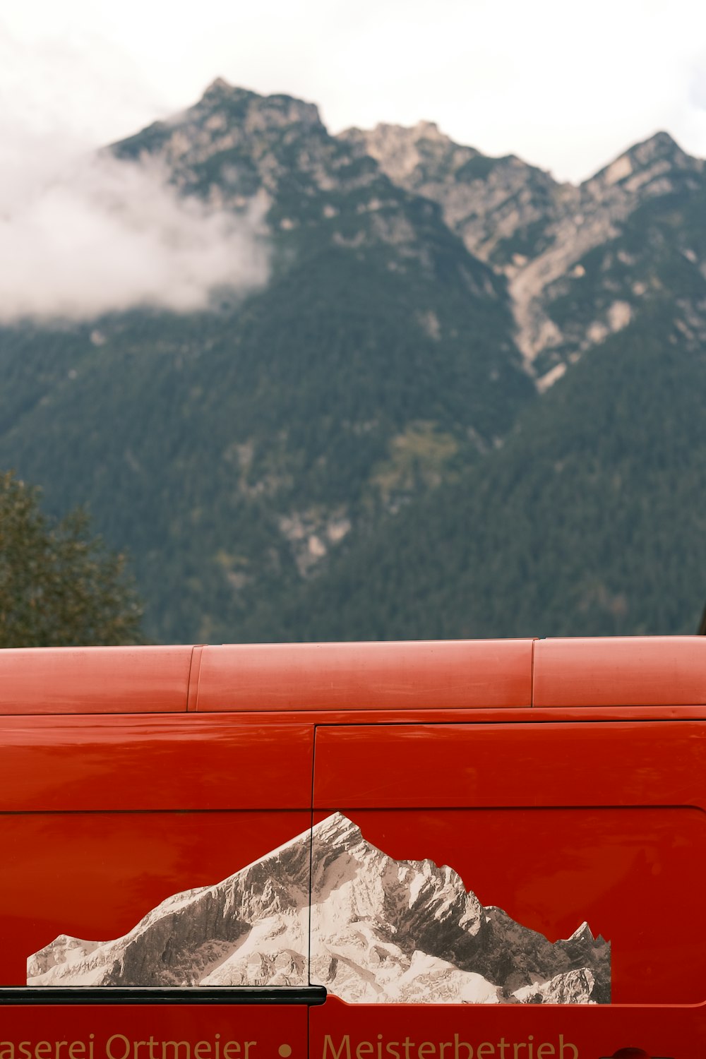a red van with mountains in the background
