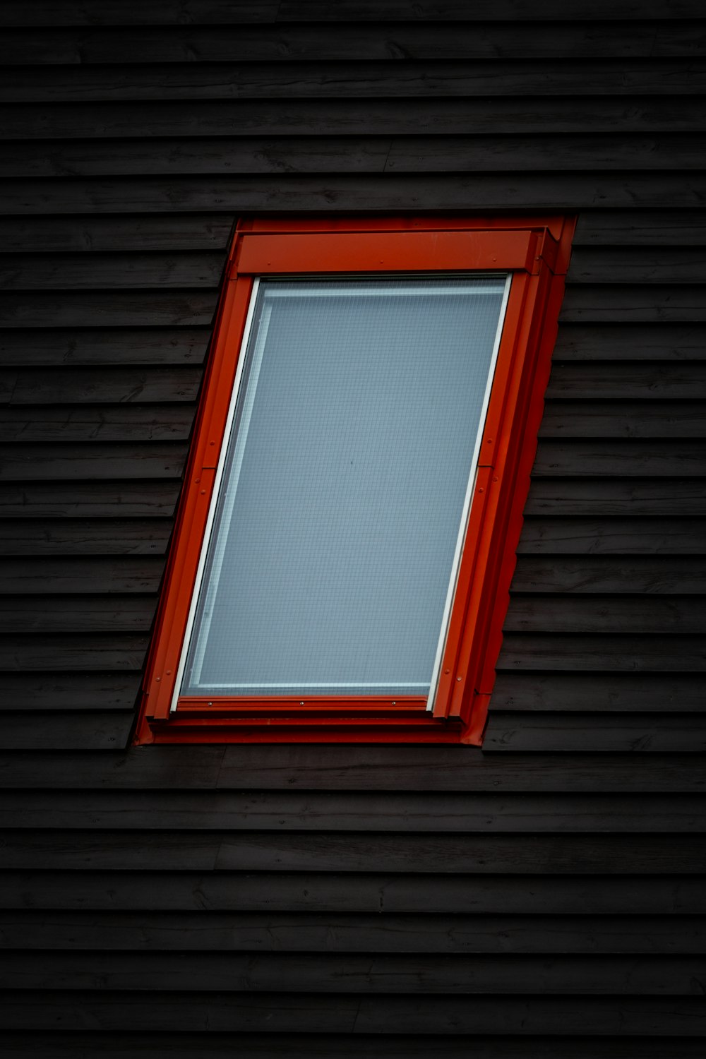 a window with a red frame on the side of a building