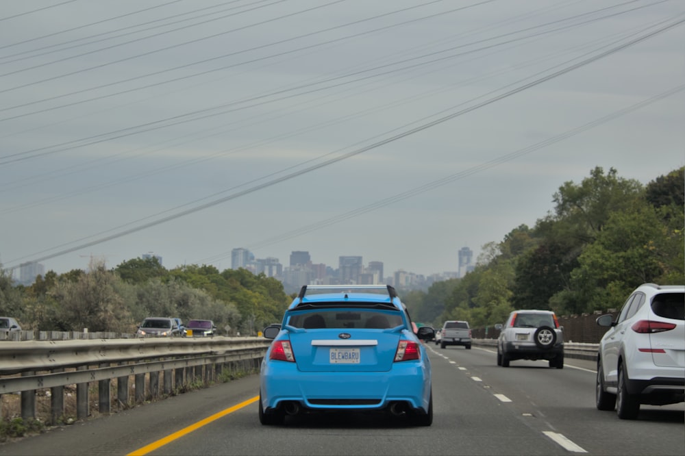 a blue car is driving down the highway