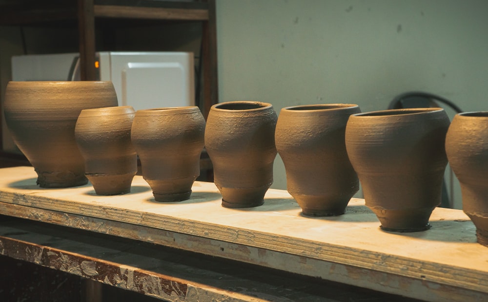 a row of clay pots sitting on top of a table