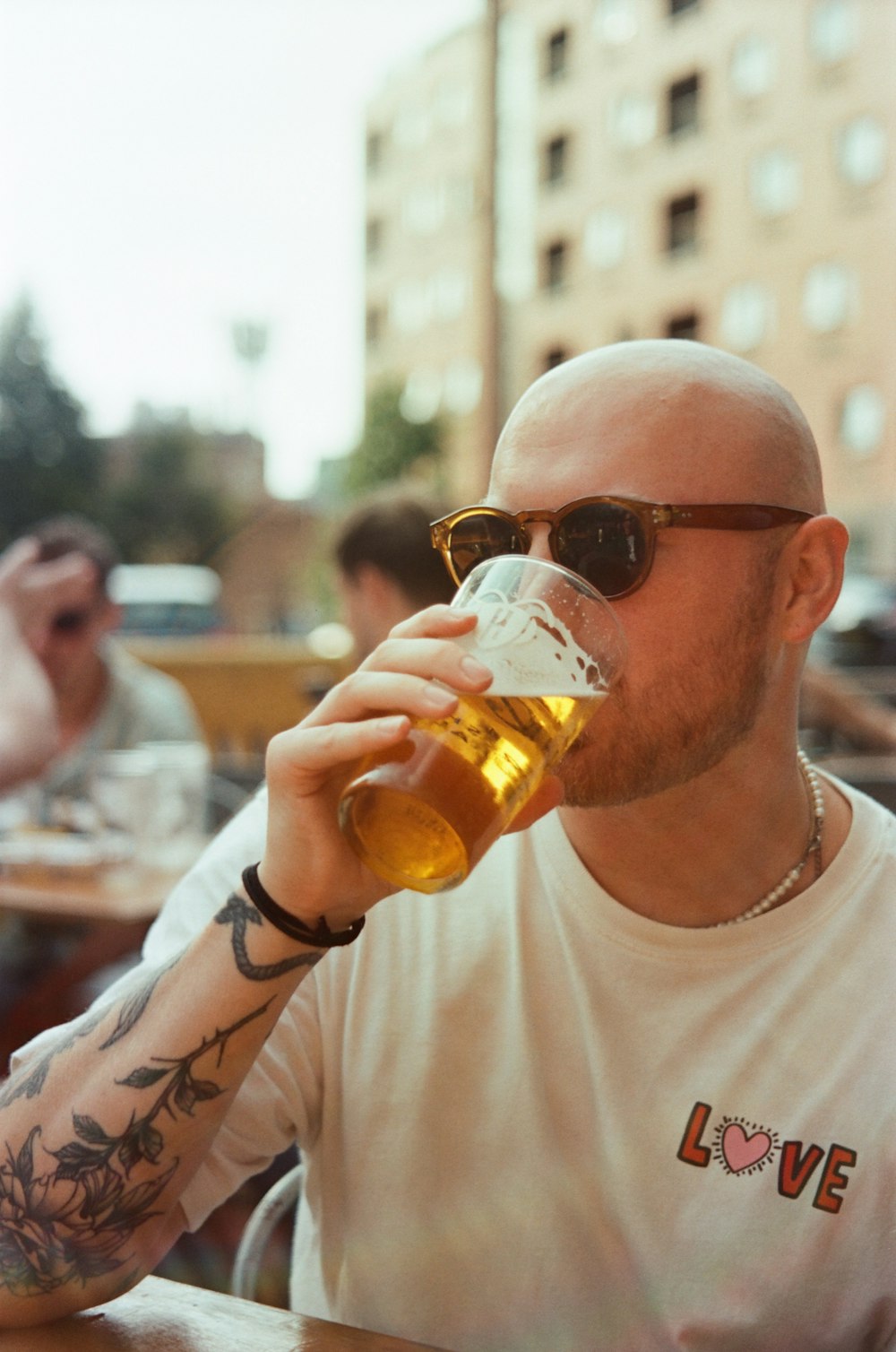 a man with a bald head drinking a beer