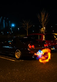 Dynamic shot of a Mustang accelerating, flames flickering from the exhaust under night lights.