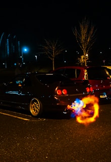 Dynamic shot of a Mustang accelerating, flames flickering from the exhaust under night lights.