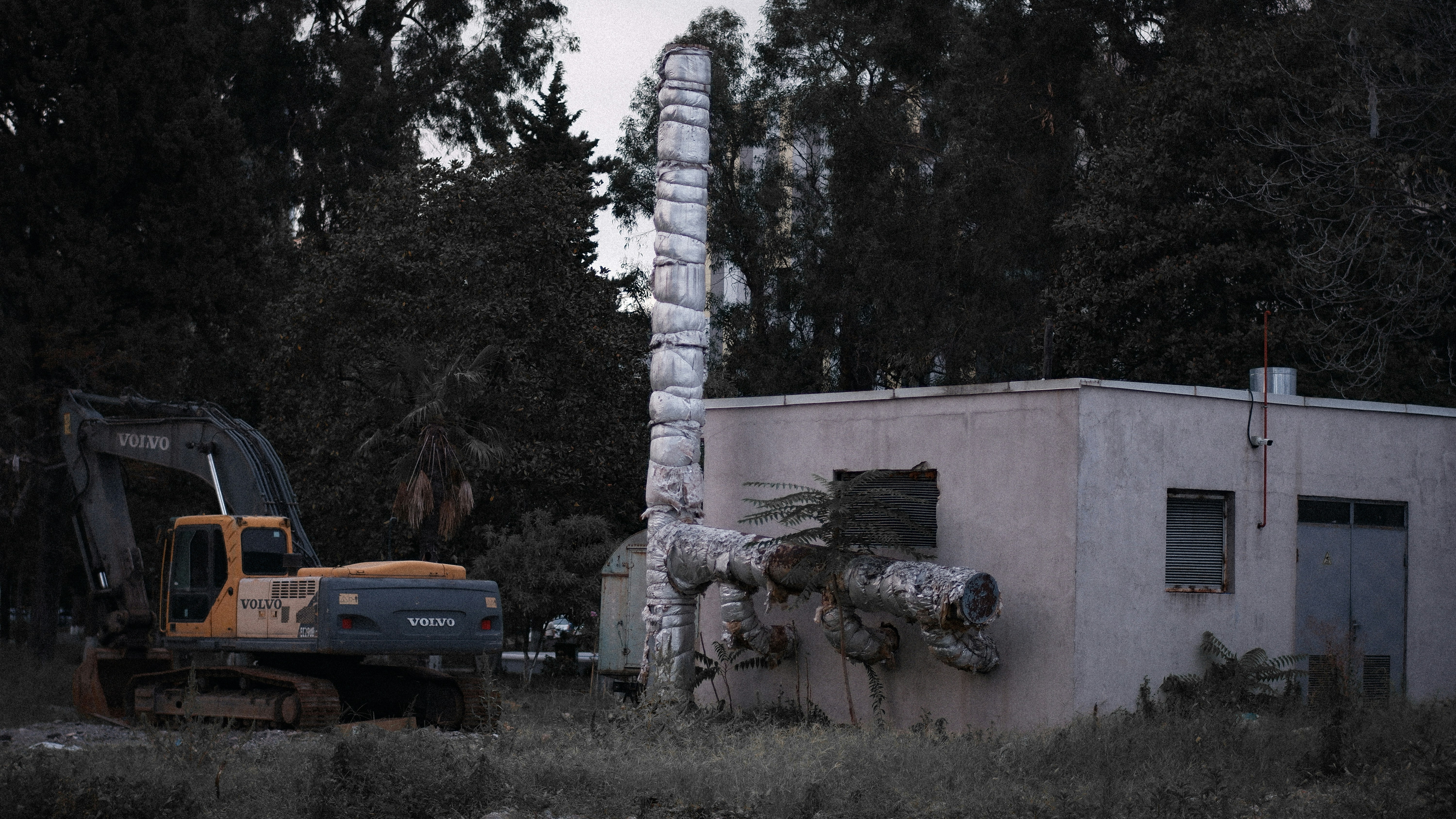 a bulldozer is parked in front of a building (Photo by Andrew Krotov on Unsplash)