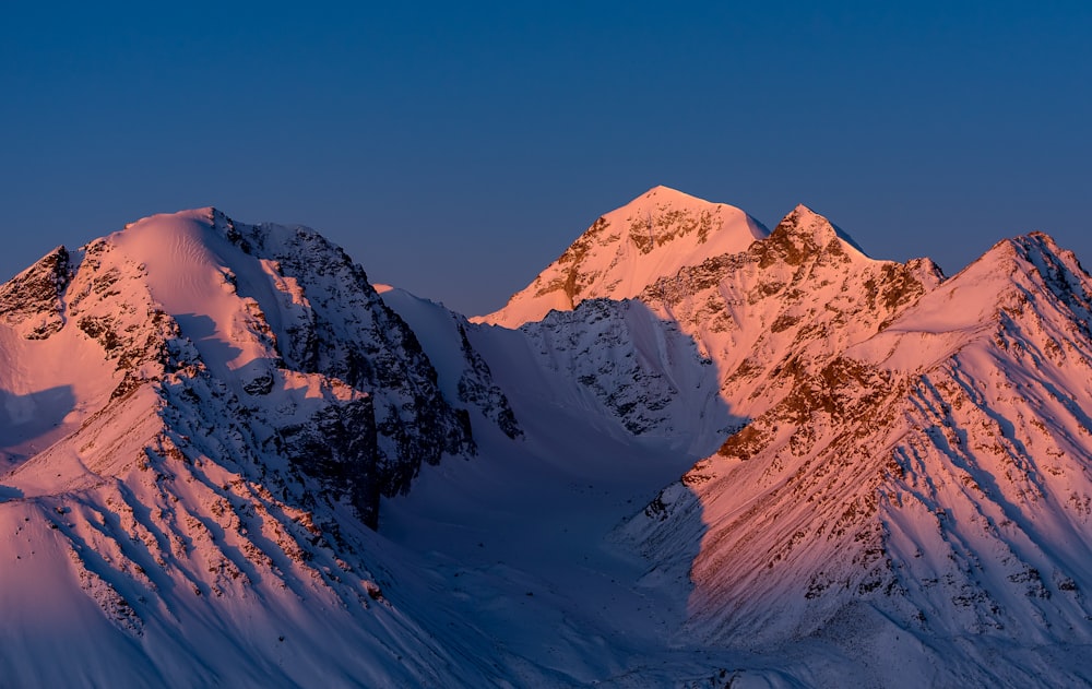 a snow covered mountain with a blue sky in the background