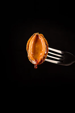 Glossy sauce dripping from a perfectly wrapped pita, set against an elegant black and gold background.