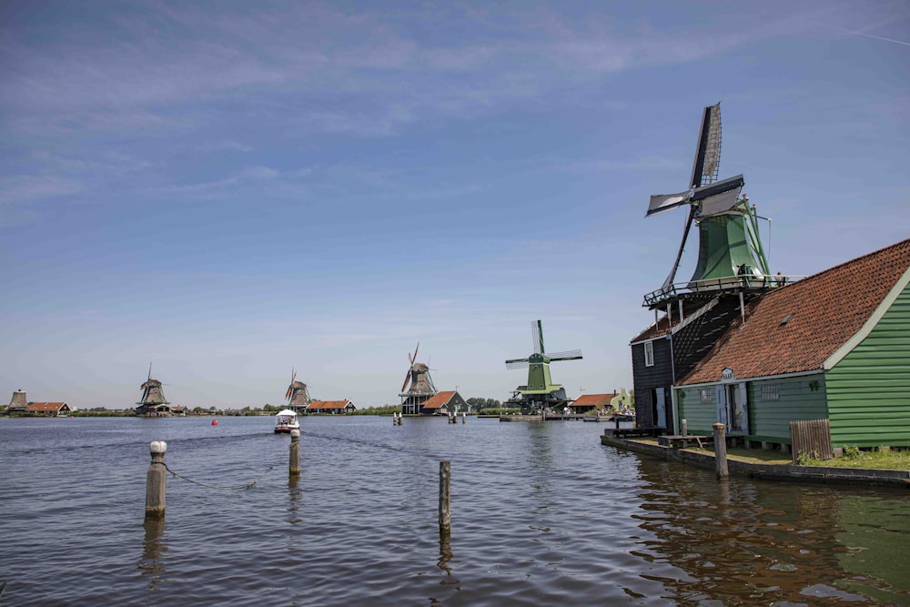 several windmills in the water near a dock
