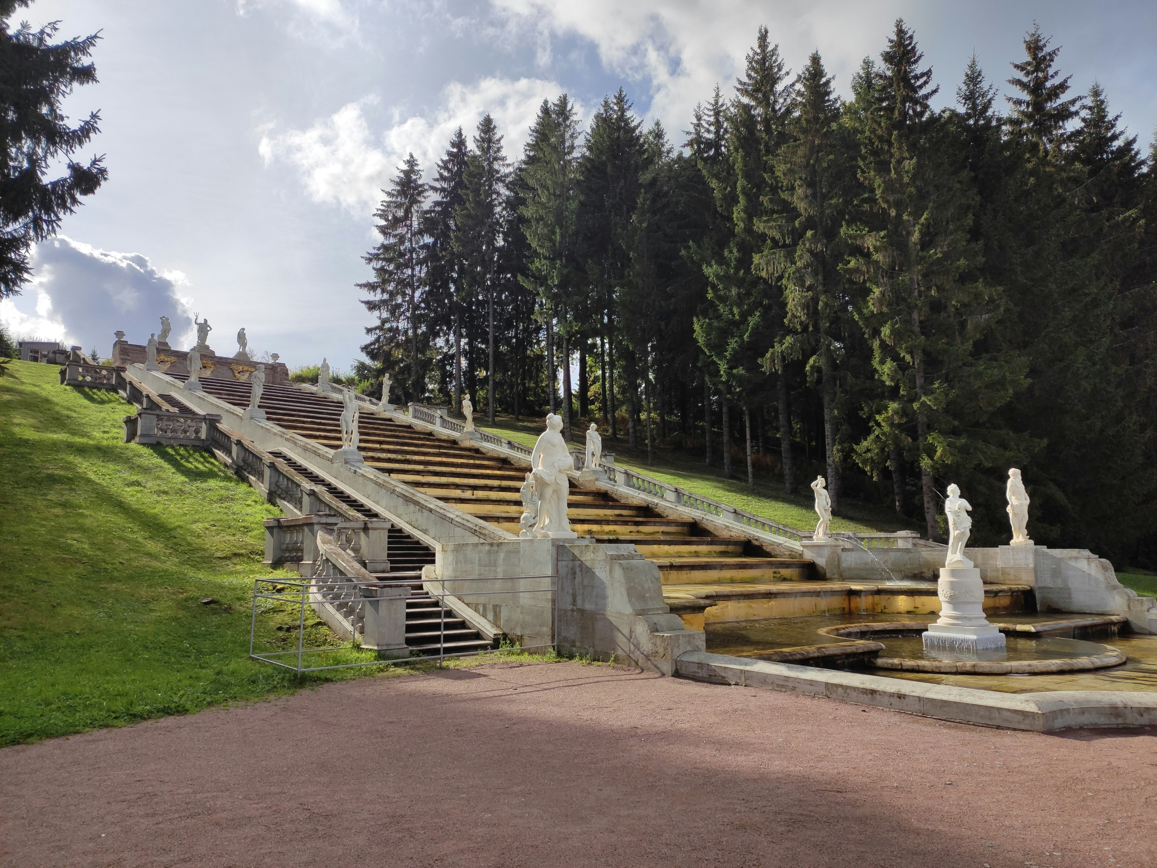 a bunch of statues sitting on top of a lush green hillside