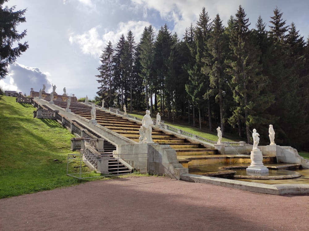 a bunch of statues sitting on top of a lush green hillside