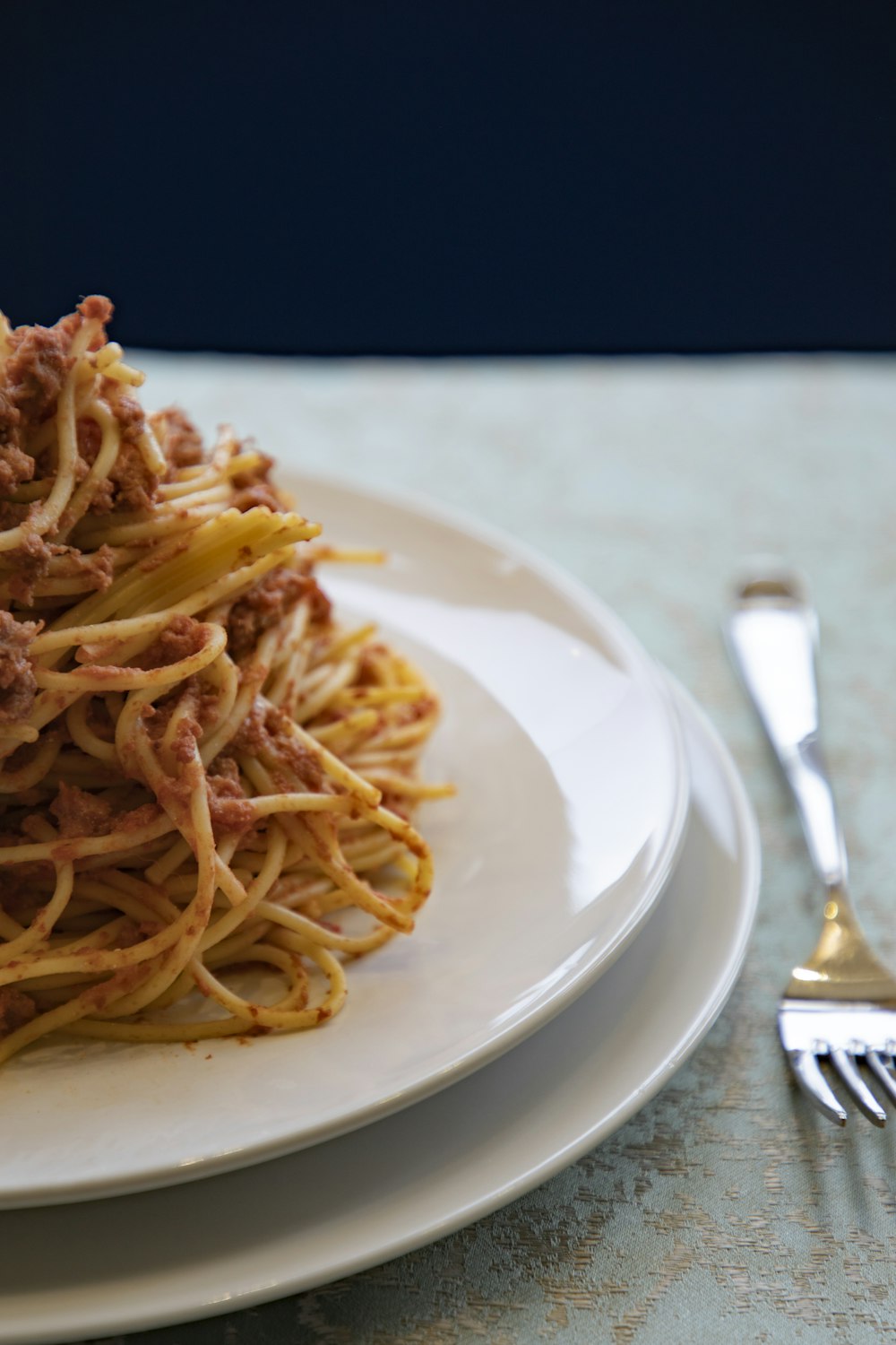 a white plate topped with spaghetti and meat