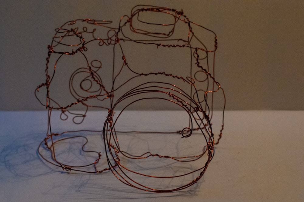 a wire sculpture of a camera on a table