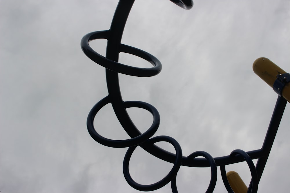 a close up of a metal sculpture with a sky in the background