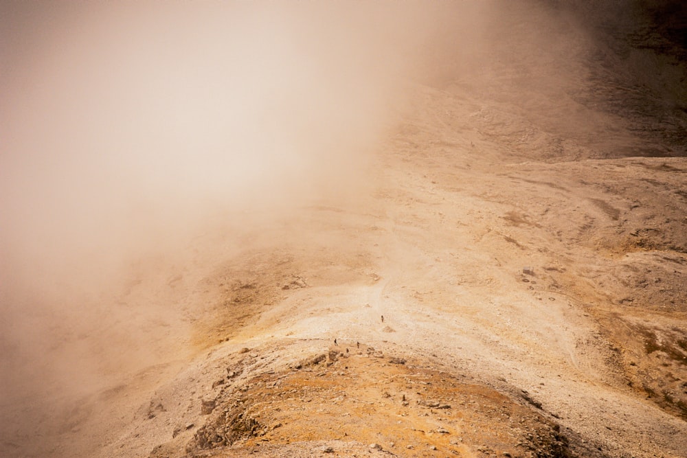 a person standing on top of a mountain in the fog