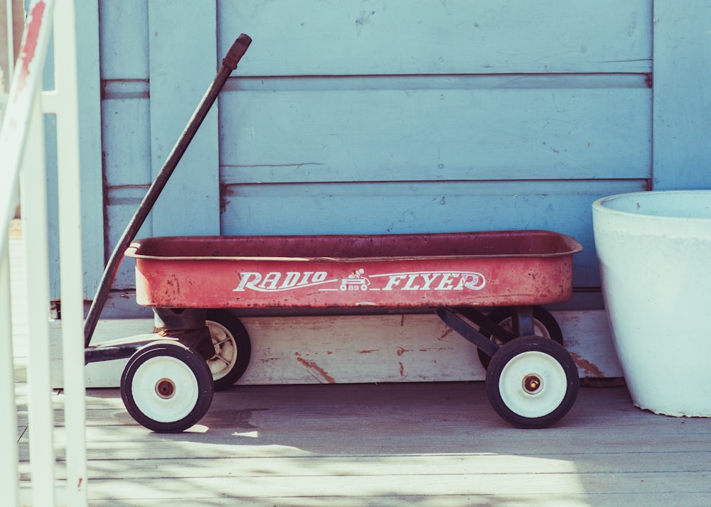 a red radio flyer wagon sitting on a porch