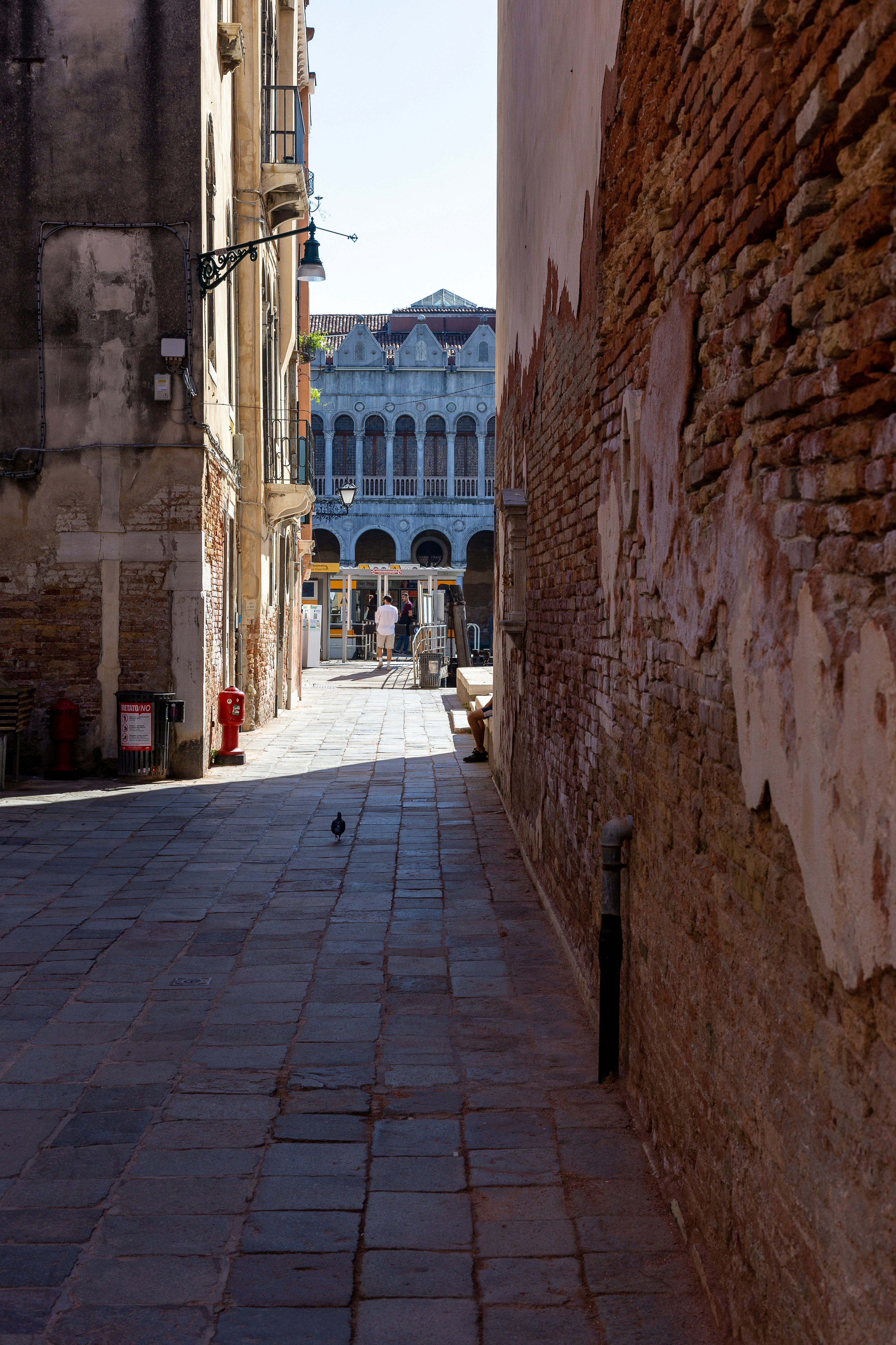 a narrow alley way with a building in the background