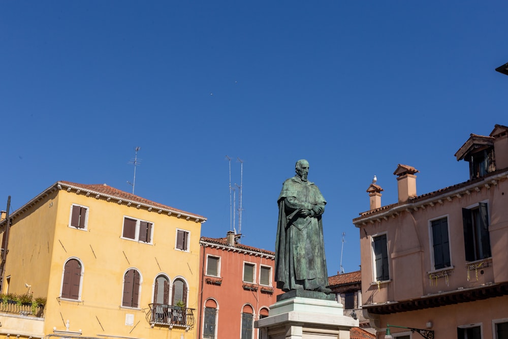 a statue of a man standing in front of some buildings